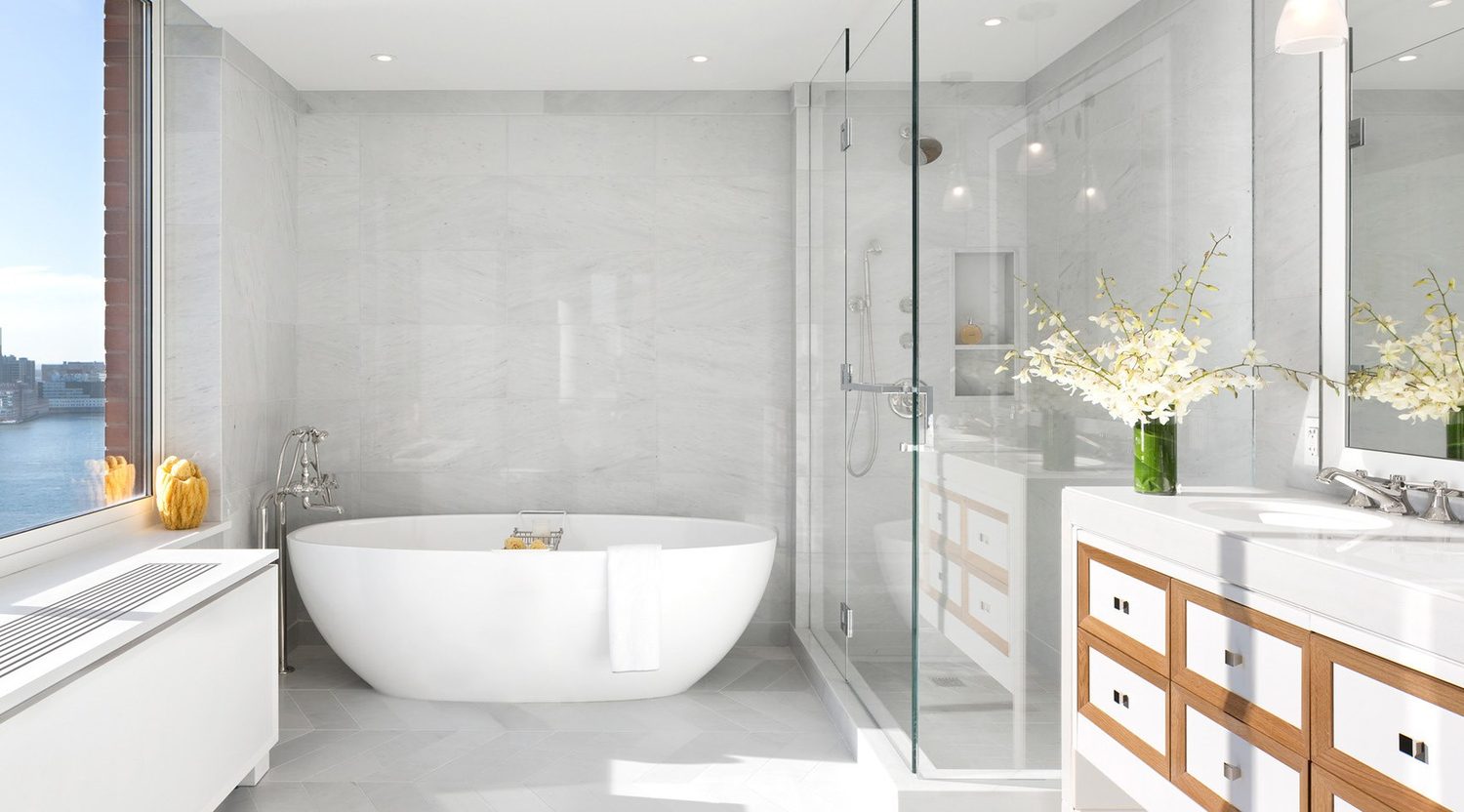 Freestanding bath beside a glazed shower enclosure