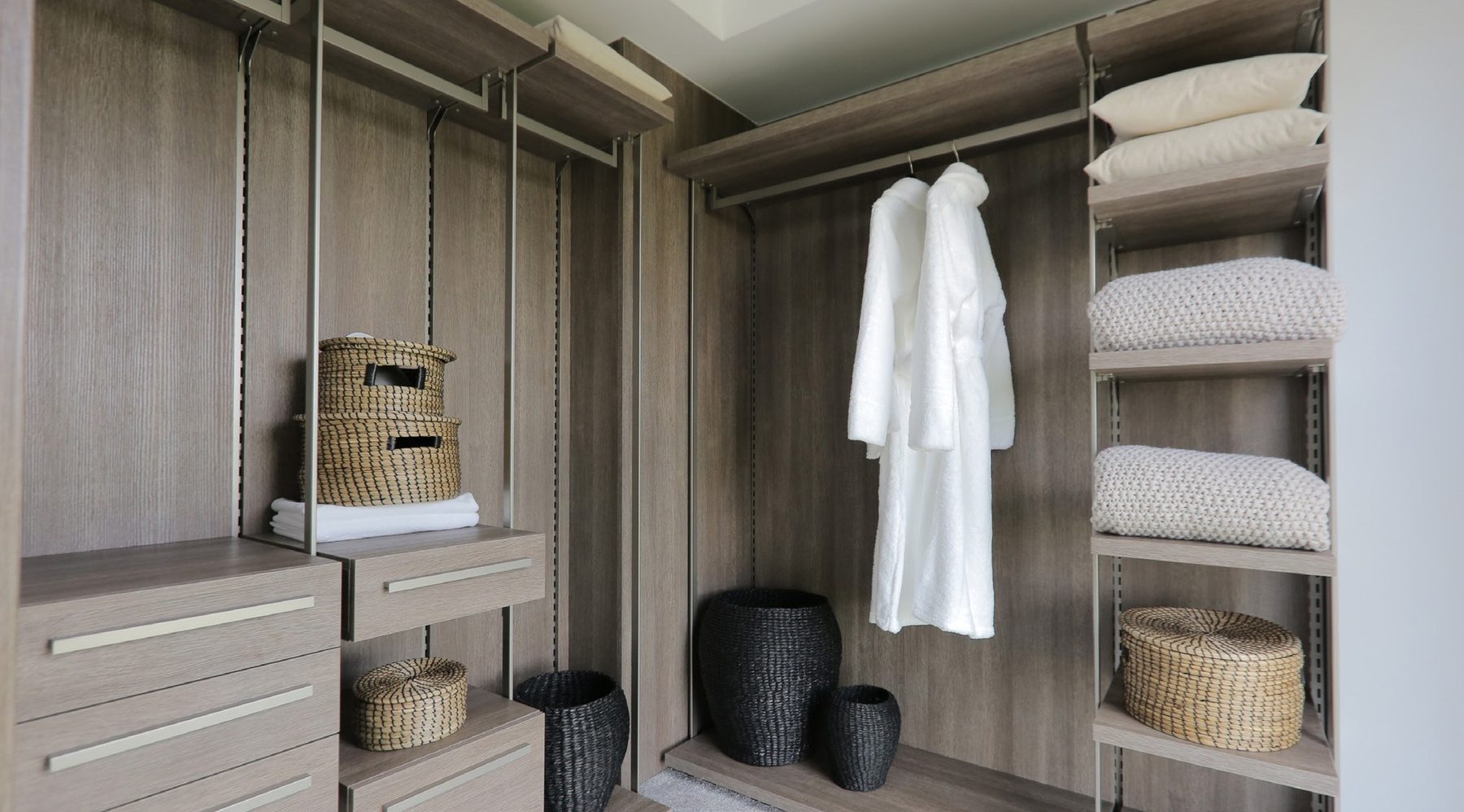 Fitted walk-in wardrobe in grey oak with a hanging robe and shelving