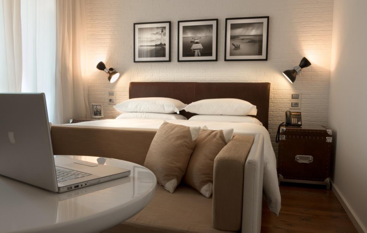 Guestroom with framed prints above a timber headboard
